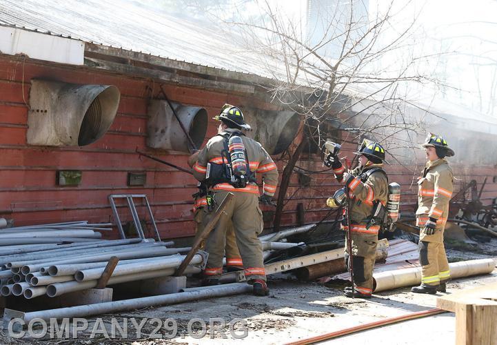 FF Nate Hudson, FF Brain Fissel, Unkown FF, and Probationary Firefighter Jason Benfield working to open up the side of a barn to gain access and over haul a fire