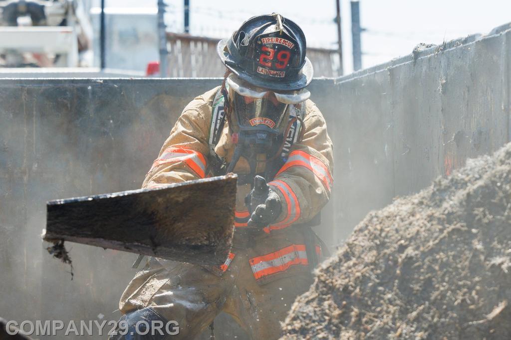 FF Isaac Lawrence performing overhaul to reach hot spots in dumpster fire